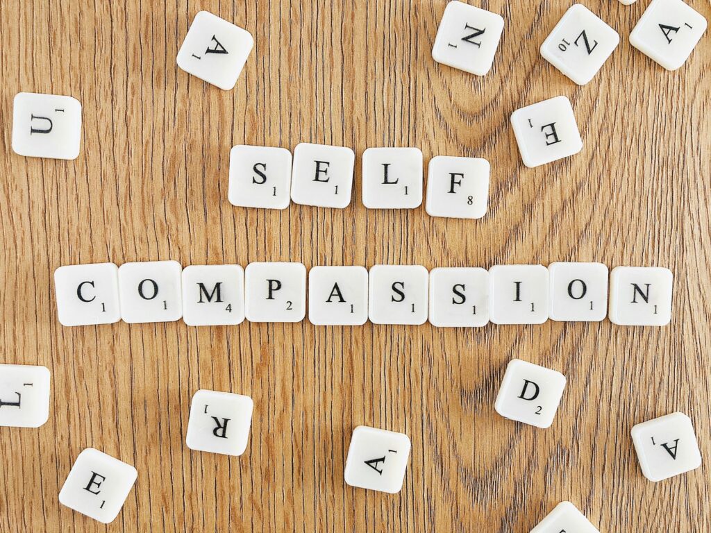 “Self compassion” written with scrabble tiles