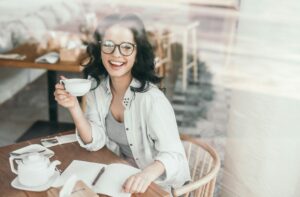 Pretty young woman in glasses relaxing at cafe
