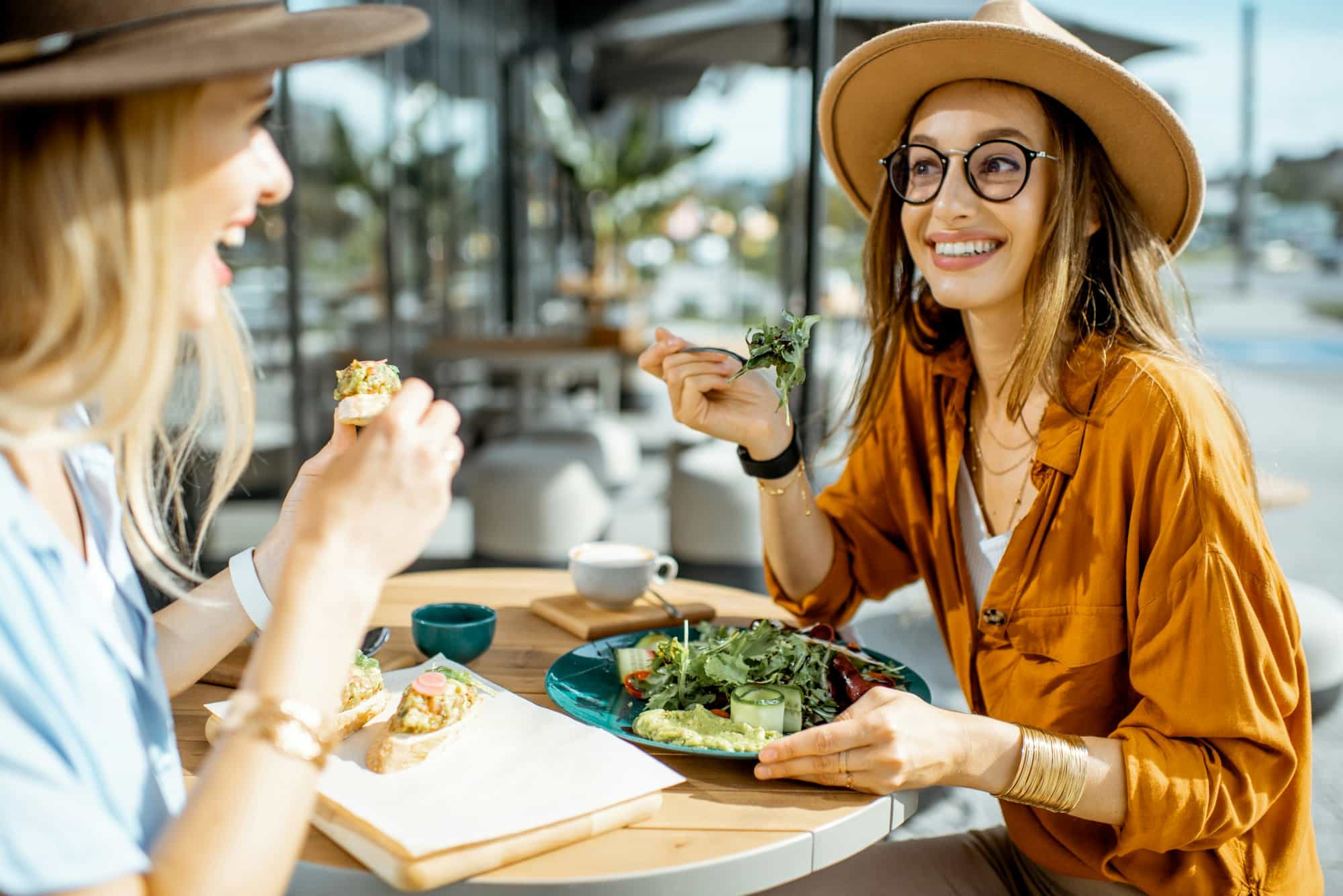 Girlfriends eating healthy food on a terrace